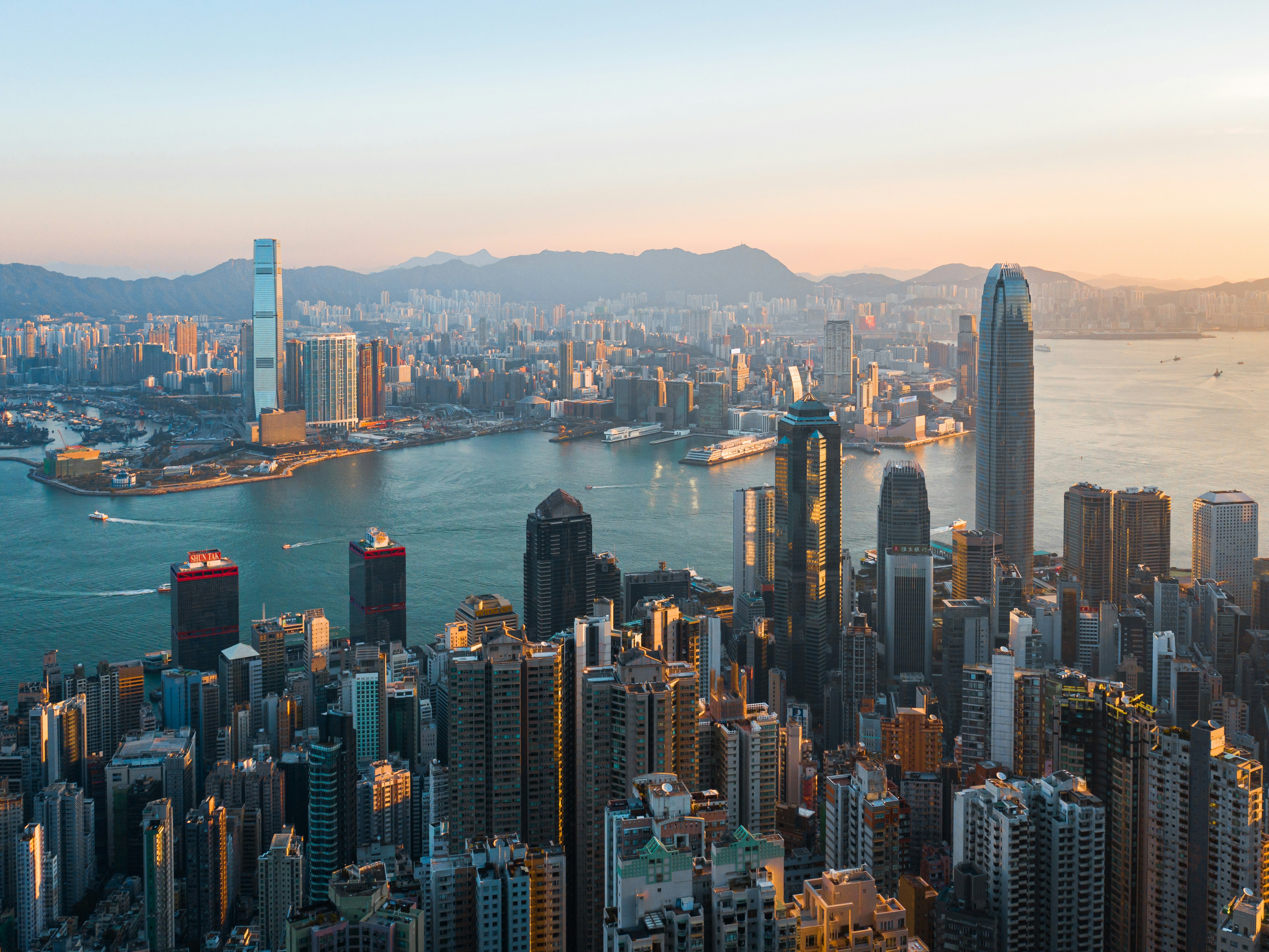 Hong Kong's Victoria Harbour and skyline in warm evening light.